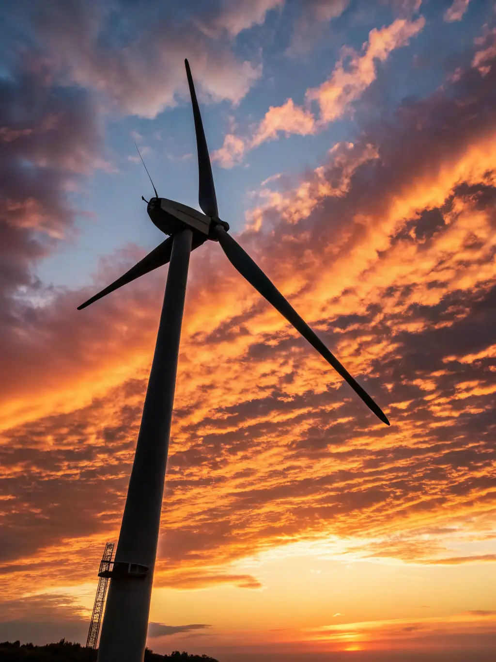 A photograph of a wind turbine against a clear blue sky, symbolizing the renewable energy sector's growth and sustainability in the financial landscape.